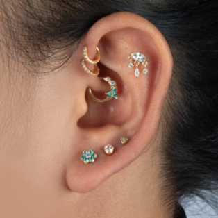 EYE-SHAPED GOLD-PLATED PIERCING ACCESSORY WITH DANGLING CRYSTALS 